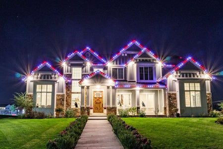 Large home outlined with colorful EverLights permanent roofline lighting